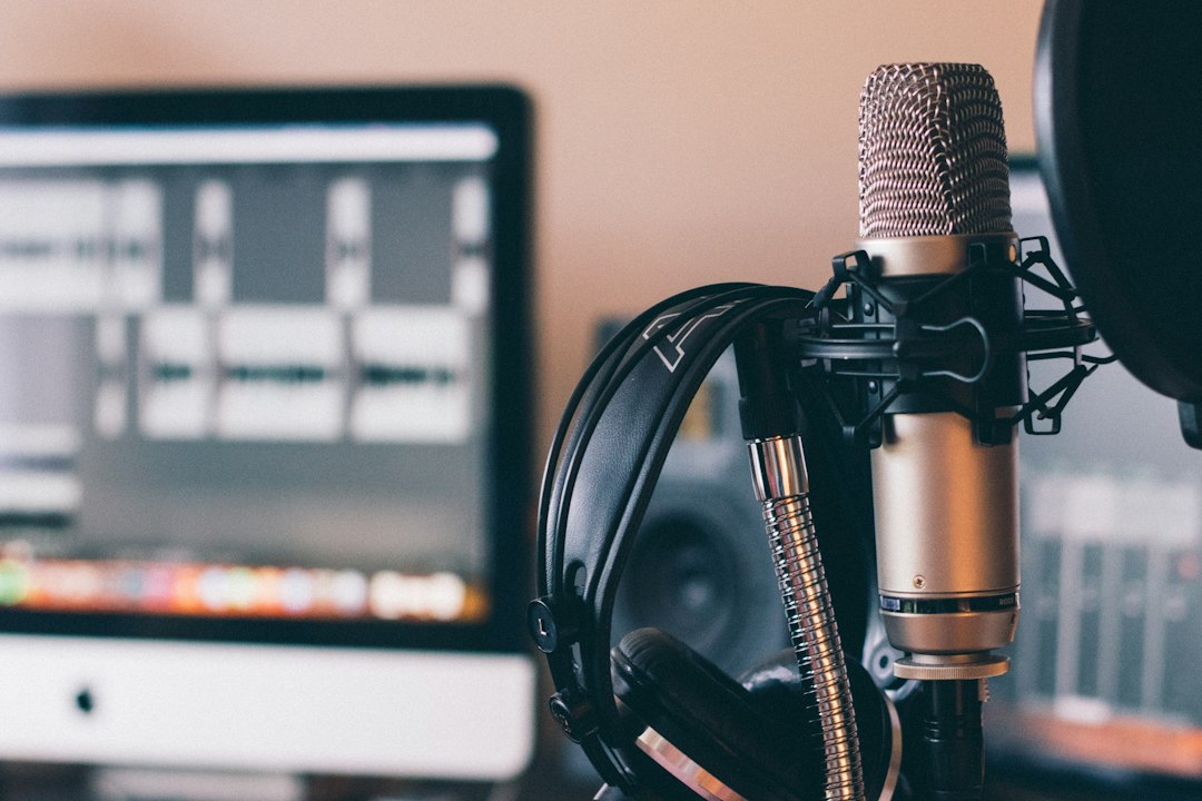Studio microphone and headphones in front of an audio editor, illustrating WAV to MP3 conversion